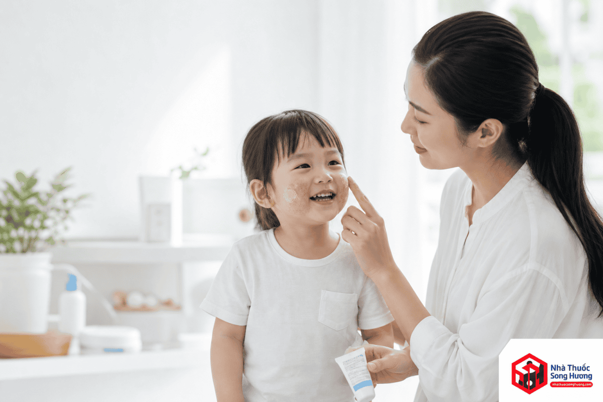 Mẹ Việt Nam bôi kem dưỡng ẩm không chứa hương liệu cho trẻ bị viêm da cơ địa mức độ nhẹ nhằm phục hồi hàng rào bảo vệ da.